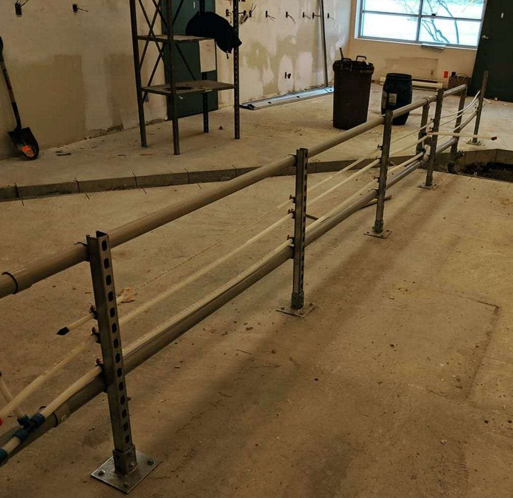 New PEX supply lines strapped to metal strut supports across an open commercial floor