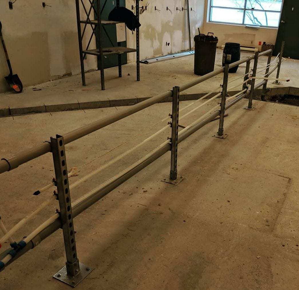 New PEX supply lines strapped to metal strut supports across an open commercial floor