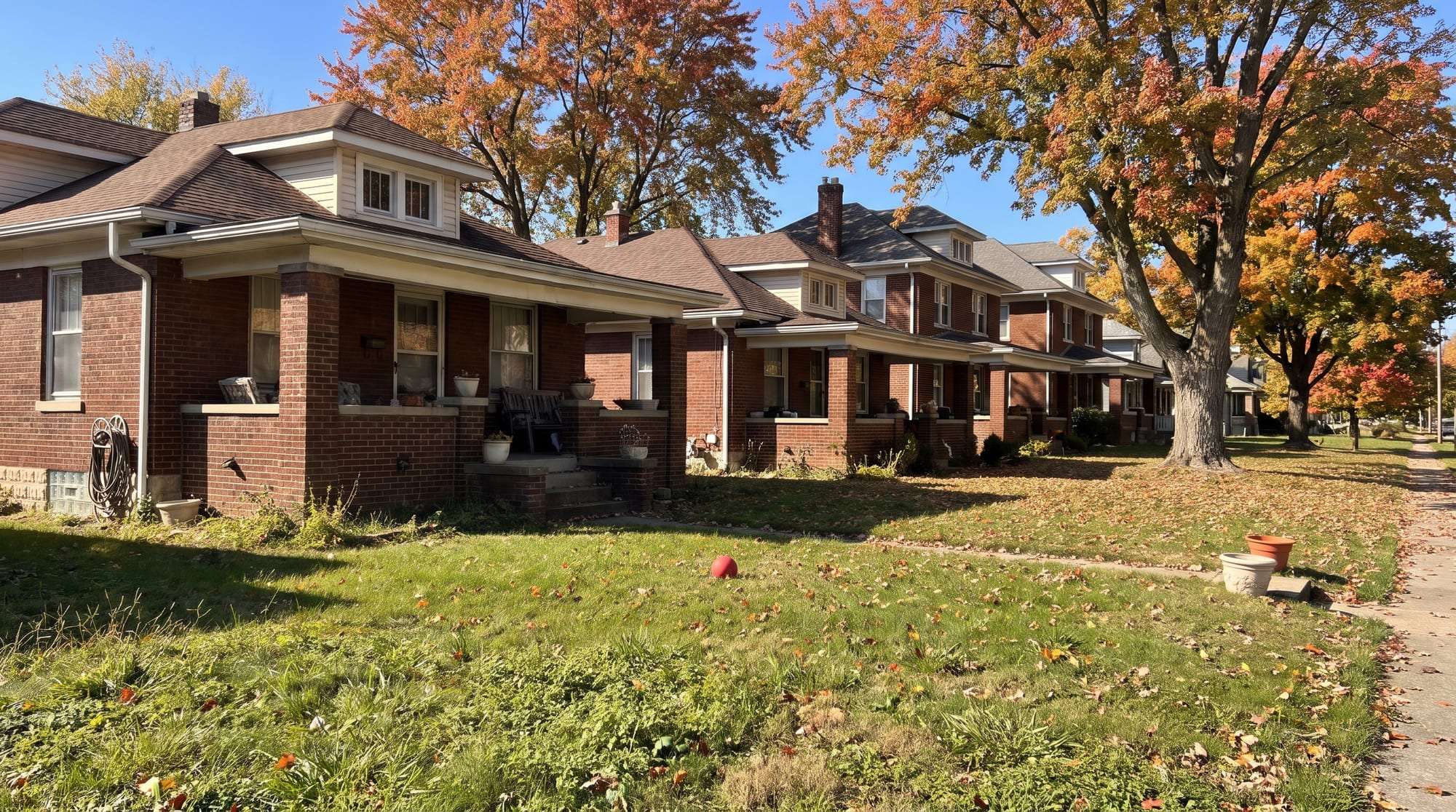 Brick bungalows and porch-fronted houses under maples in autumn color